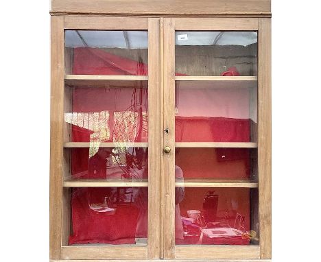 A two door glazed beech cabinet, enclosing shelves, height 100cm, width 85cm, depth 26cm.Provenance: From the Estates of June