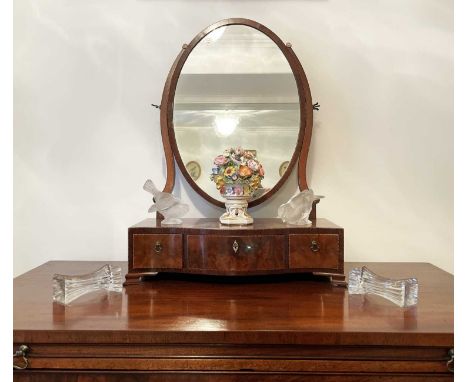 A George III mahogany oval swing dressing table mirror, the serpentine base fitted with three drawers, height 81cm, width 44c