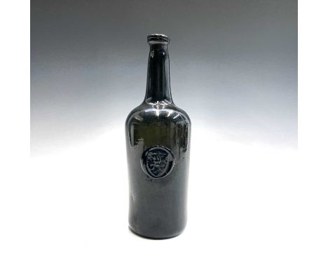A late 18th century sealed wine bottle, circa 1790, the seal with a hand on a shield and initialled JC, height 29cm.Provenanc