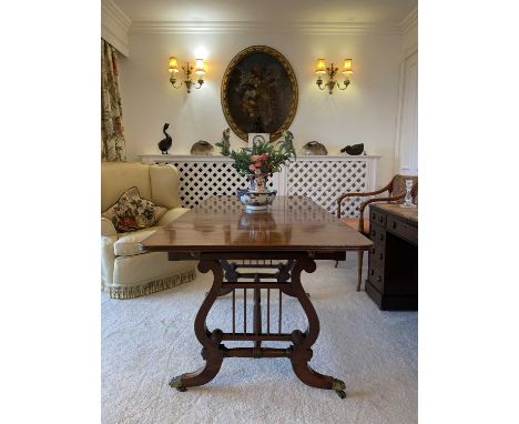 A Regency mahogany sofa table, fitted with two real and two opposing dummy drawers raised on lyre end supports with a reeded 