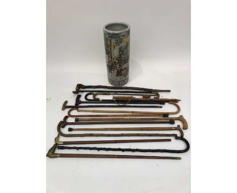 A collection of assorted walking sticks and canes, contained in an Oriental stick stand (14 sticks, a pipe and the stand).