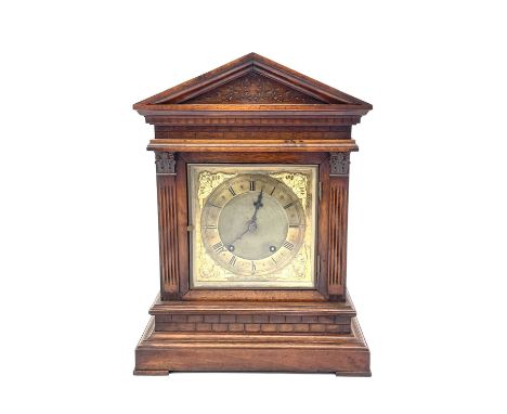A German walnut architectural bracket clock with brass dial and Arabic numerals, height 42cm.