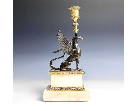 A French bronze and ormolu candlestick, late 19th century, modelled as a winged griffin, on a stepped rectangular base, heigh