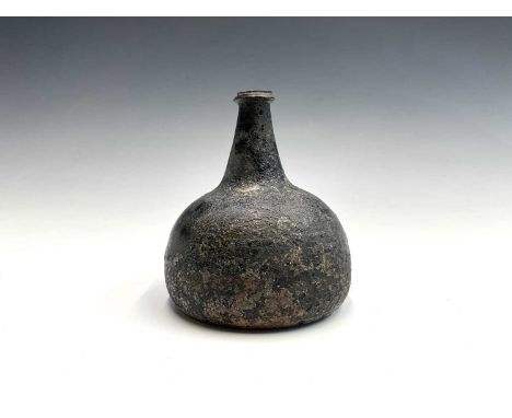 An early 18th century green onion wine bottle, height 16cm.Provenance: From the Estates of June Barrington Ward & Maggie Came