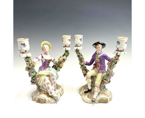 A pair of Meissen figural candelabra, late 19th century, modelled as a lady and a gentleman in 18th century dress, each seate