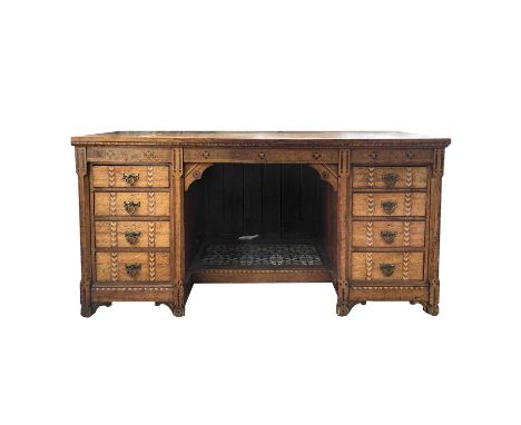 A Victorian Gothic revival oak ebony and boxwood inlaid twin pedestal desk or dressing table, in the manner of Charles Bevan,