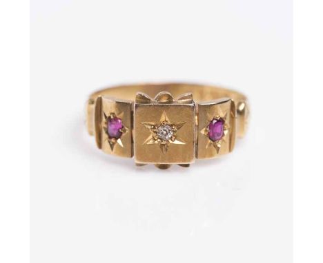 RUBY AND DIAMOND THREE STONE RING
with a central round diamond and two oval rubies, in star settings, in eighteen carat gold,