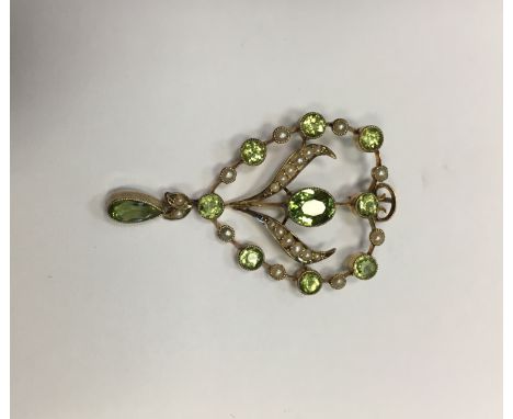 EDWARDIAN PERIDOT AND SEED PEARL HOLBEIN ON A CHAIN
of scrolling floral openwork form, with a central oval peridot surrounded