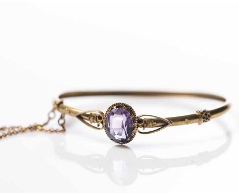 VICTORIAN AMETHYST BANGLE
the central oval amethyst measuring approximately 12 x 9.6mm, with a floral design to each side, un