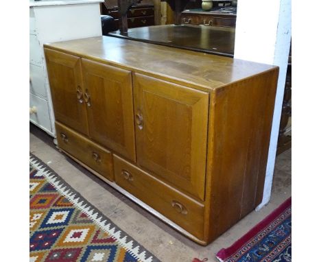 A mid-century elm Ercol sideboard, with 3 cupboards and 2 drawers under, W130cm, H76cm, D45cm 
