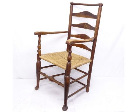 An Antique ladder-back rush-seated kitchen elbow chair on pad foot 