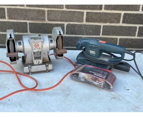 A tabletop grinder and a Black &amp; Decker sander. 