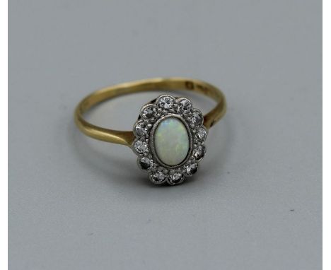 An opal and diamond dress ring in yellow metal. Set with 12 x 0.03ct round brilliant cut diamonds. Gross weight approx 2.4gm,