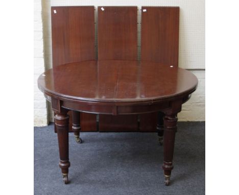 A 19th century mahogany extending dining table, the circular top opening to accommodate three leaves, on turned tapering reed