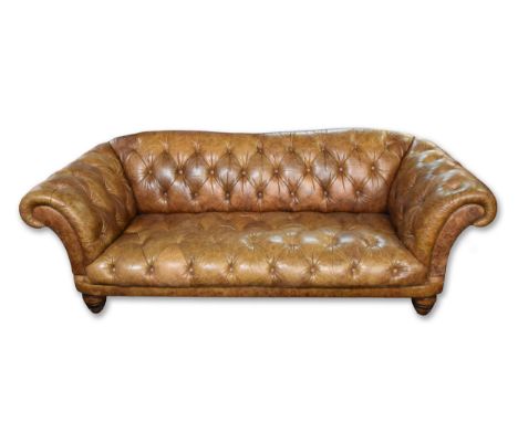 A large brown leather button back Chesterfield style sofa, supported on turned wooden legs, 229 cm wide, 102 cm deep.