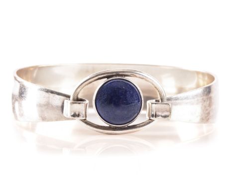 A 1970's Danish sterling silver bangle set with a cabochon blue stone by Niels Erik, diameter 6cm.31.1 grams.