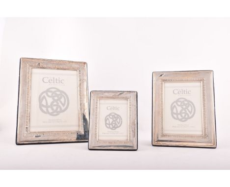 A set of three silver photograph frames with Celtic border design, graduating in size, aperture sizes 9 x 6cm, 13 x 9cm, and 