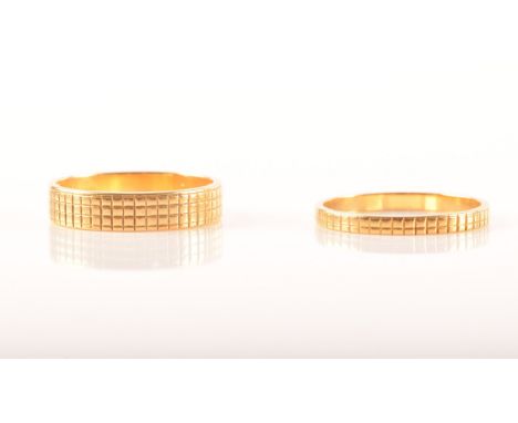 A pair of two 22ct yellow gold wedding bands, with linear engraving, partial hallmarks for London, one 4mm wide, size K 1/2, 