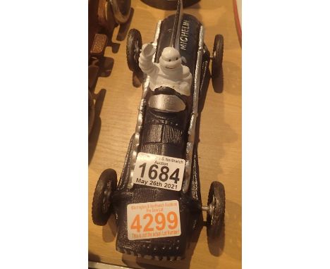 Cast iron Michelin Man in blue car, L: 26 cm. P&amp;P Group 2 (£18+VAT for the first lot and £3+VAT for subsequent lots) 