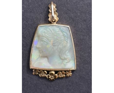 An art deco style carved opal 9ct gold pendant, relief decorated with a female head, 1.3" overall.