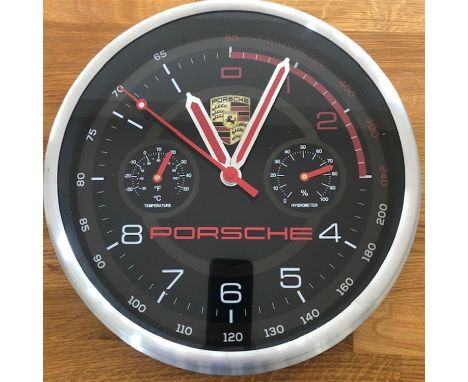 A Porsche-themed wall clock with Quartz movement. Black ground with red batton hands, subsidiary thermometer and hydrometer a