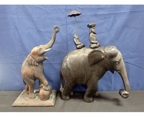 TWO CEYLONESE CARVED HARDWOOD ELEPHANTS19th century, the first on wooden plinth with trunk raised, 52cm high; the second with