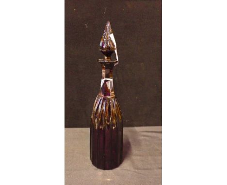 AN AMETHYST GLASS DECANTERwith panelled and ribbed body, tapered stopper for same, 38cm high