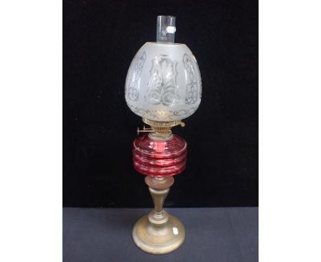 A VICTORIAN OIL LAMP WITH FACETED CRANBERRY GLASS FONT and etched beehive-shape shade