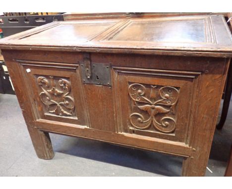 A PANELLED OAK COFFER, WITH CARVED FRONTand one back panel carved with a 'Romayne' type head 98cm wide