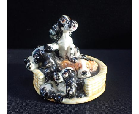 A W. GOEBEL POTTERY FIGURE OF A SPANIEL AND PUPS IN WICKER BASKETmodelled by Albert Staehle, dated 1958, 11cm high x 12cm wid