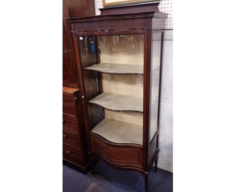 AN EDWARDIAN MAHOGANY DISPLAY CABINETwith serpentine shaped front, on square tapering legs and with fluted frieze 71cm wide, 