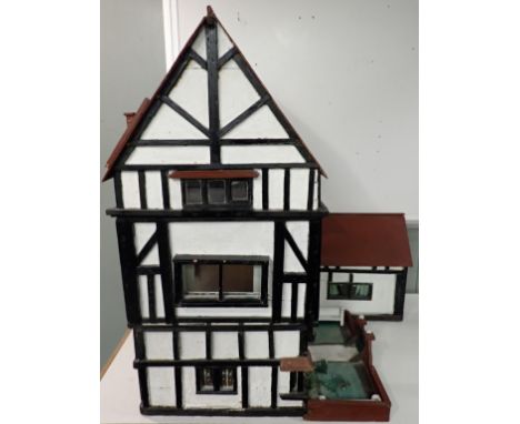 A LARGE 1920s TIMBER-FRAMED DOLL'S HOUSE; 'THE HALL' home-built, the interior with panelling, moulded ceiling, fireplaces etc