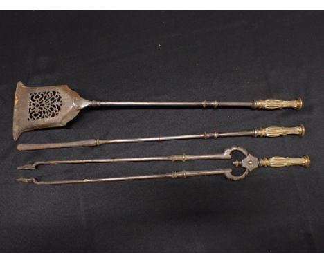 A SET OF 19th CENTURY STEEL AND BRASS FIRE TOOLStongs, poker and pierced shovel, with cast brass handles