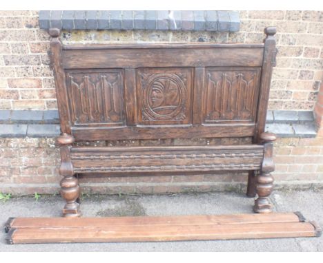 A JACOBEAN STYLE OAK DOUBLE BEDthe headboard with central 'Romayne' carved panel, and beech side rails with metal joints 136c