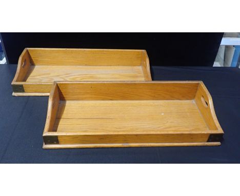 A PAIR OF EARLY 20th CENTURY BRASS-BOUND LIGHT OAK BOOK TROUGHSwith pierced handles, each 28 x 66cm (some loss to lower corne