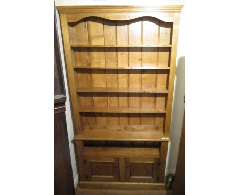 Modern light oak open bookcase, the moulded cornice above five open shelves, alcove and two panel doors on a plinth base, 82i