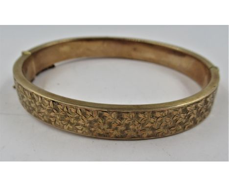 9ct Gold floral engraved, hinged bangle, 10g(Hinge to clasp - 60mm) x 52mmSome dents to the plain section as shown in photo 