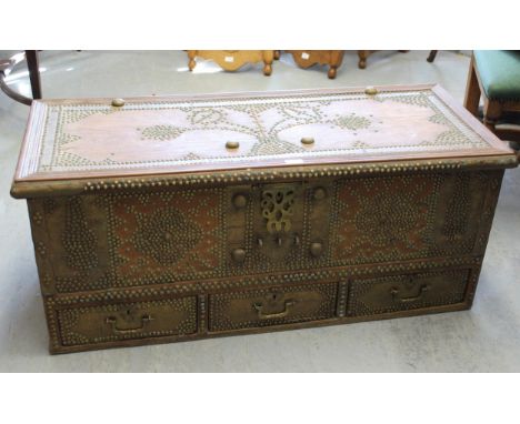 Middle Eastern hardwood and brass mounted trunk, the hinged lid above a studwork decorated front with a decorative lock above