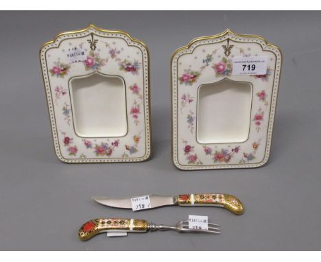 Two Royal Crown Derby floral decorated porcelain photograph frames, together with a Royal Crown Derby knife and fork 