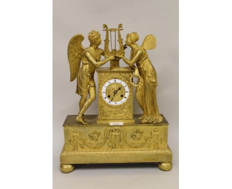 Early 19th Century French ormolu mantel clock, the circular enamel dial flanked by two figures of angels, the dial inscribed 