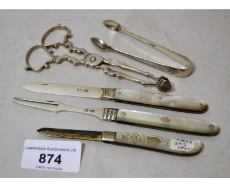 Two silver bladed, mother of pearl fruit knives, a similar fork, a pair of sugar nips, and a pair of sugar tongs 