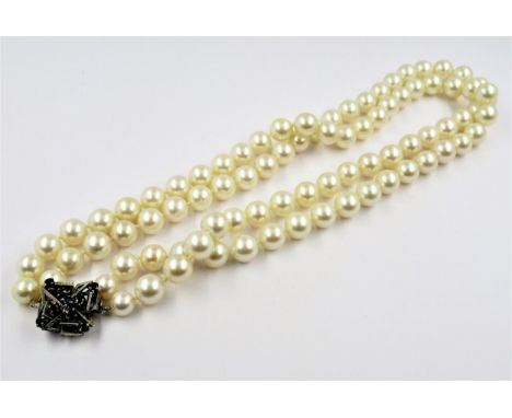 Double row uniform cultured pearl necklace with 14ct white gold and sapphire set clasp, the pearls each approximately 8mm dia