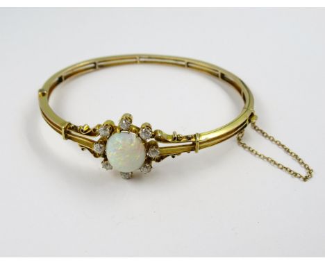 Edwardian gold bangle, set with an oval opal surrounded by eight diamonds 