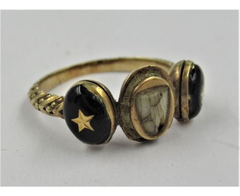 Unusual 19th Century gold memorial ring, inset with a baby tooth, flanked by two enamel decorated hinged compartments 