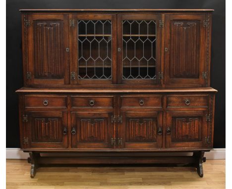 An Old Charm style oak dresser or side cabinet, rectangular top above a pair of leaded glazed doors enclosing two shelves, fl