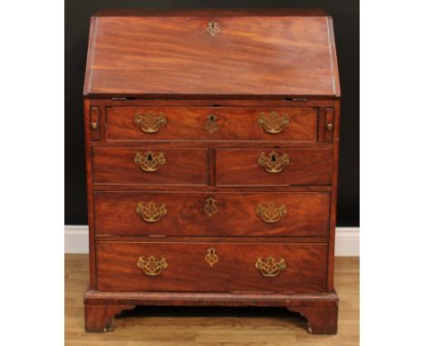 A George III mahogany bureau, fall front enclosing a well, pigeonholes and small drawers, above one long, two short and two f