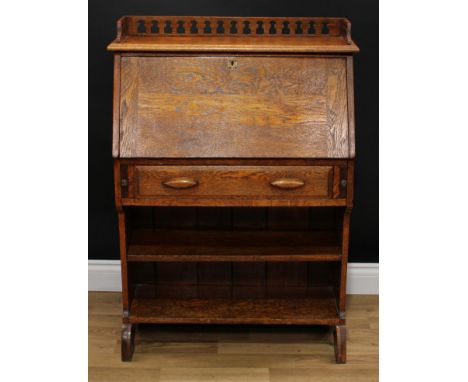 An Arts &amp; Crafts oak student's bureau, pierced three-quarter gallery and fall front enclosing pigeonholes, above a drawer