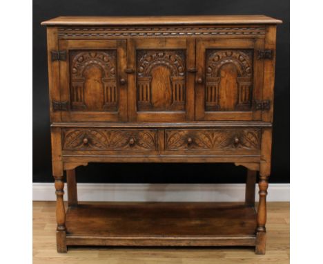 A 17th century style oak 'Monastic' side cabinet, probably Rupert Griffiths, rectangular top with moulded edge above a chip-c