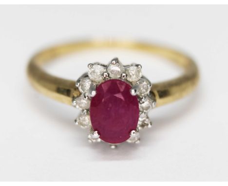 A diamond and ruby cluster ring, marked '375', gross wt. 2.6g, size O.  Condition - evidence of treatment to central stone, g