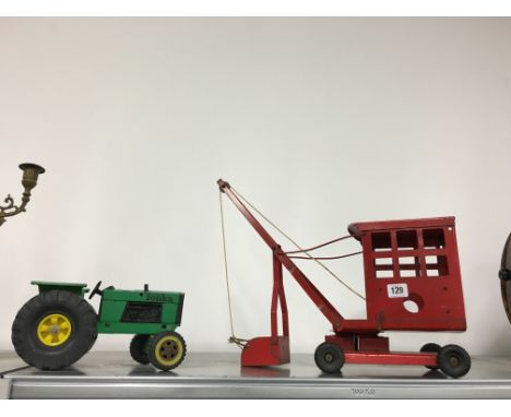 A Triang red painted metal toy crane together with a Tonka tractor.